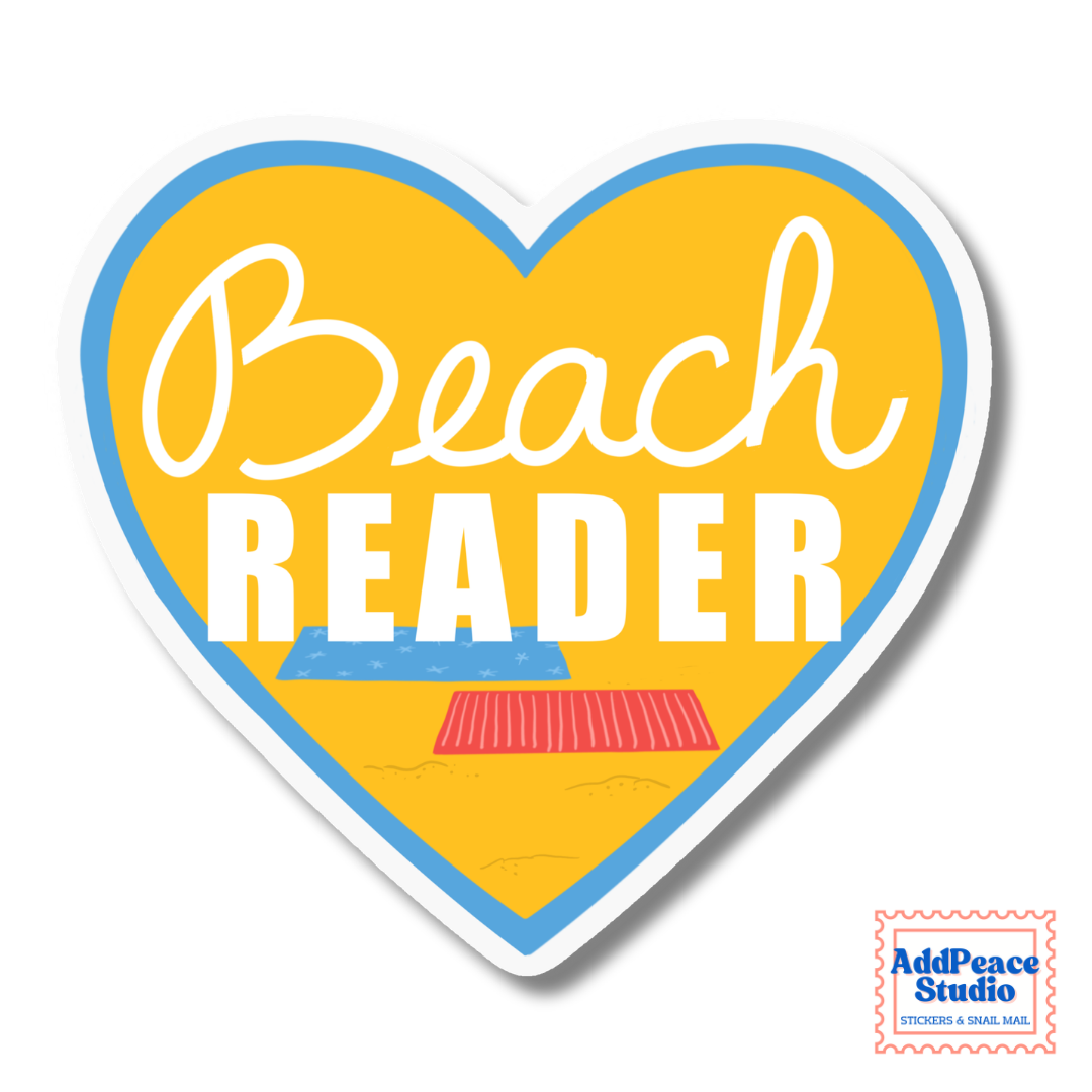 A heart-shaped sticker with a yellow background, blue border, and white text reading 'Beach READER.' Small beach-themed illustrations appear near the bottom, and a small 'AddPeace Studio' logo is visible in the lower right corner.