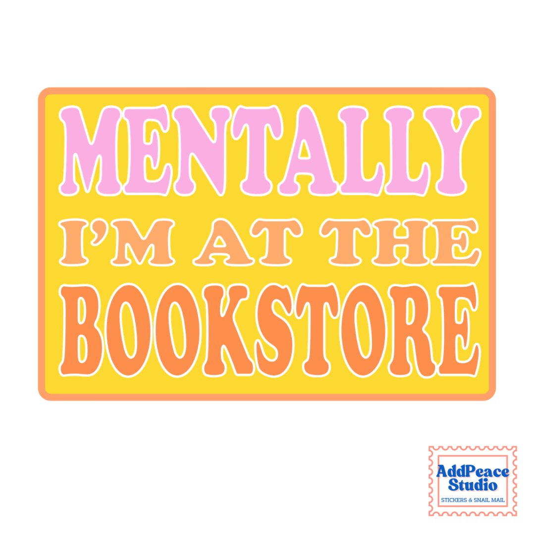 A rectangular printed sticker or sign with the phrase “MENTALLY I’M AT THE BOOKSTORE” in large retro bubble letters. The background is bright yellow, with “MENTALLY” in pink and “I’M AT THE BOOKSTORE” in orange, all outlined in white.