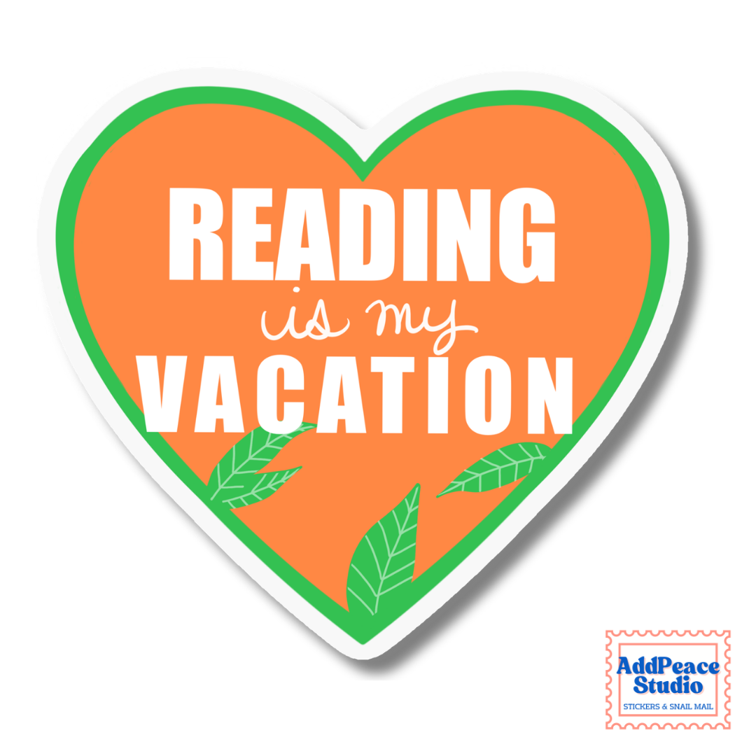 A heart-shaped sticker with the text 'READING is my VACATION' in white lettering on an orange background, bordered by a green inner outline and a white outer border. Small green leaf illustrations appear near the bottom.