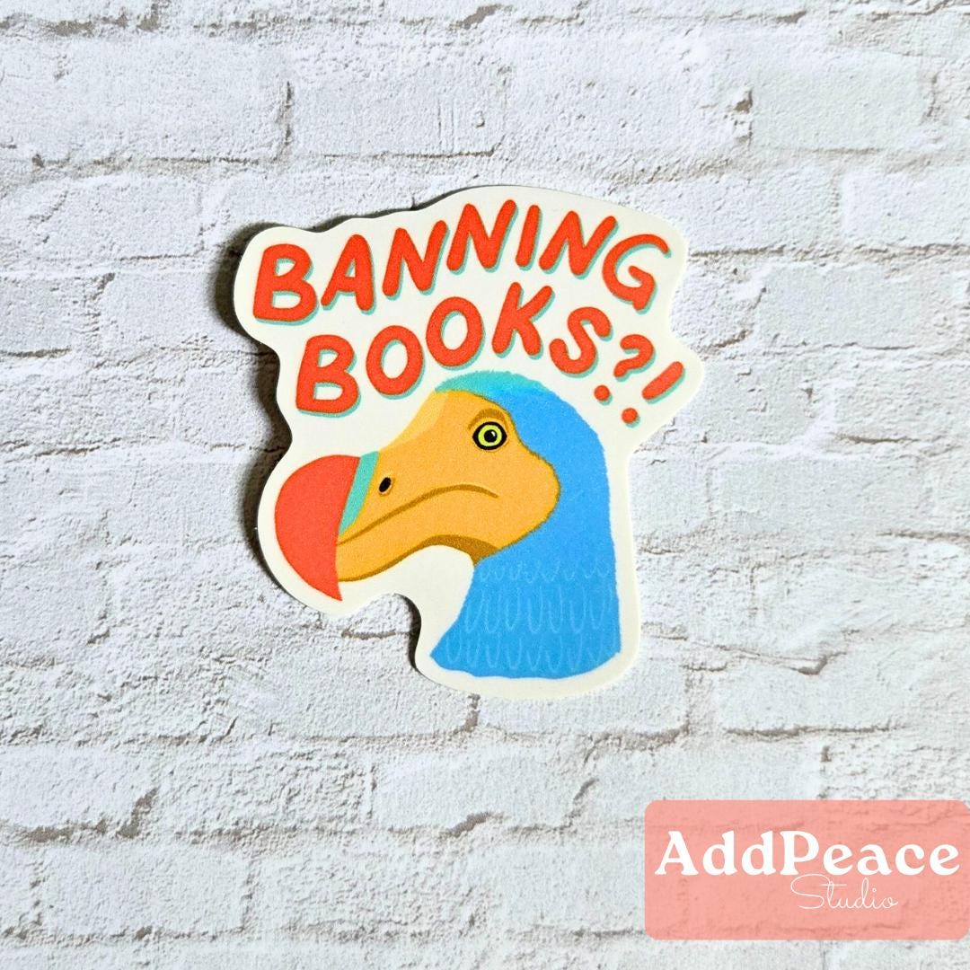 Sticker with a cartoon dodo bird and text 'Banning Books?' on a white brick wall background, with 'AddPeace Studio' branding.
