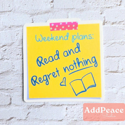 Yellow sticky note with 'Weekend plans: Read and Regret nothing' text on a white brick wall background.