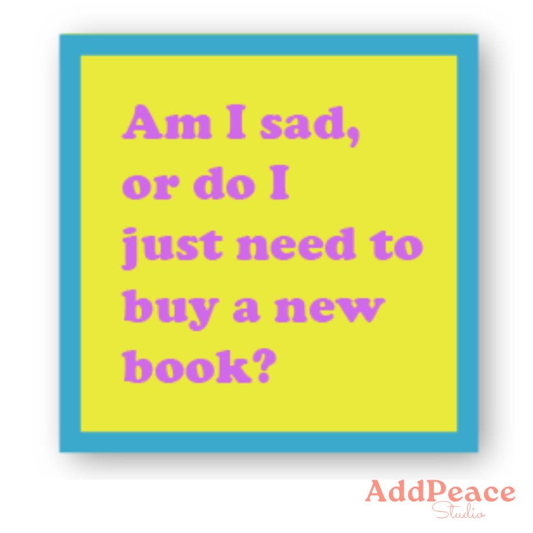 Yellow sticker with blue border containing text 'Am I sad, or do I just need to buy a new book?' on a white background.