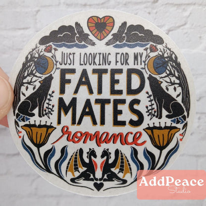 Circular sticker with decorative border and text 'Just looking for my fated mates romance' held against a light background.