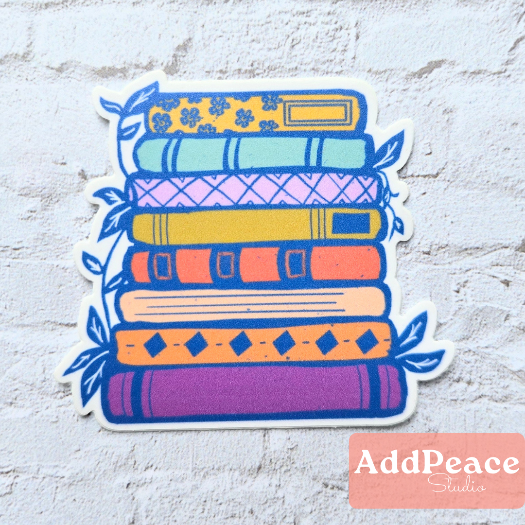 Colorful stack of books sticker with 'AddPeace Studios' logo on a textured white background