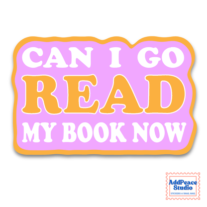 A die-cut sticker with the text 'CAN I GO READ MY BOOK NOW' in white and orange lettering on a pastel pink background with an orange border. A small 'AddPeace Studio' logo is visible in the bottom right corner.