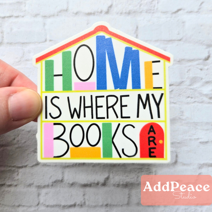 House shaped matte vinyl sticker with illustrated bookshelves and “Home Is Where My Books Are” text