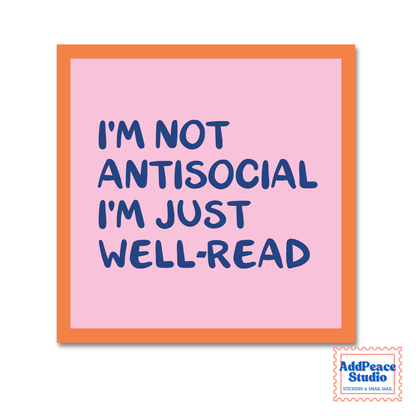 A square pink sticker with an orange border and blue text that reads 'I'M NOT ANTISOCIAL I'M JUST WELL-READ'. A small AddPeace Studio logo is visible in the bottom right corner.