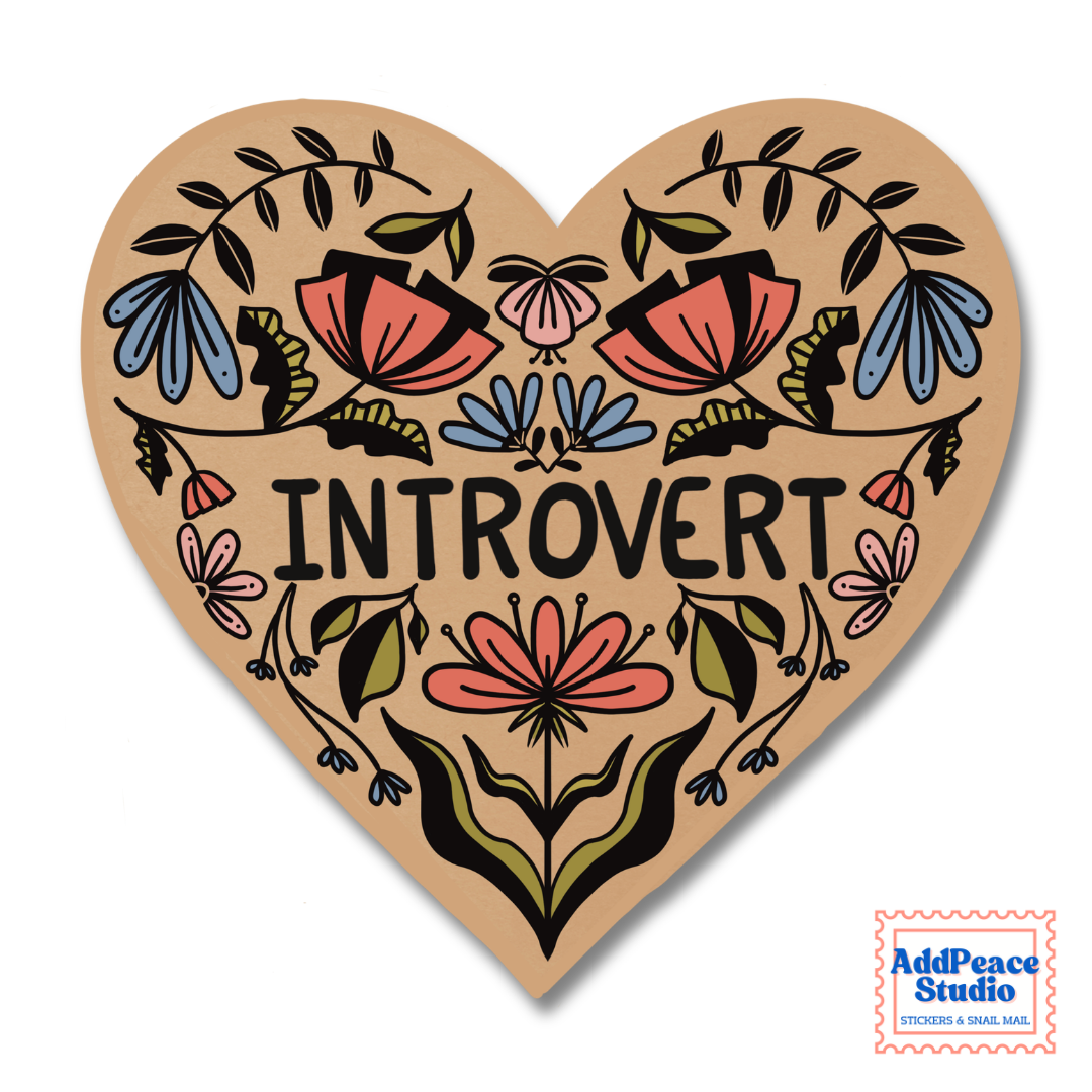 A heart-shaped sticker featuring the word 'INTROVERT' in black capital letters, surrounded by colorful hand-drawn floral and botanical illustrations in pink, blue, green, and black. A small 'AddPeace Studio' logo is visible in the bottom right corner.