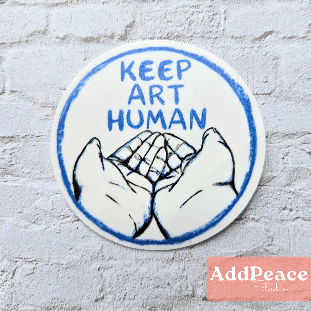Circular sticker with 'Keep Art Human' text and hands on a textured white background, featuring the AddPeace Studio logo.