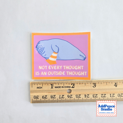 A rectangular sticker with a light blue seal illustration and the text 'NOT EVERY THOUGHT IS AN OUTSIDE THOUGHT' on a pink background with an orange border, shown above a wooden ruler for scale. An AddPeace Studio logo appears in the bottom right corner.