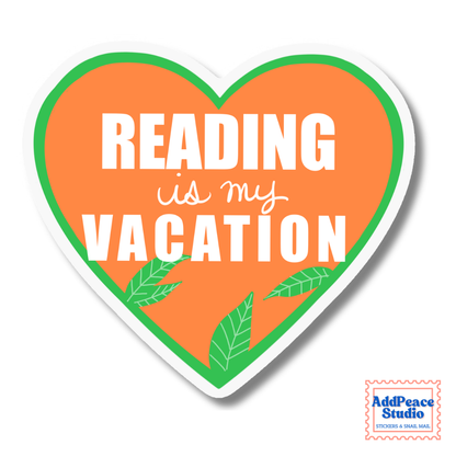 A heart-shaped sticker with the text 'READING is my VACATION' in white lettering on an orange background, bordered by a green inner outline and a white outer border. Small green leaf illustrations appear near the bottom.