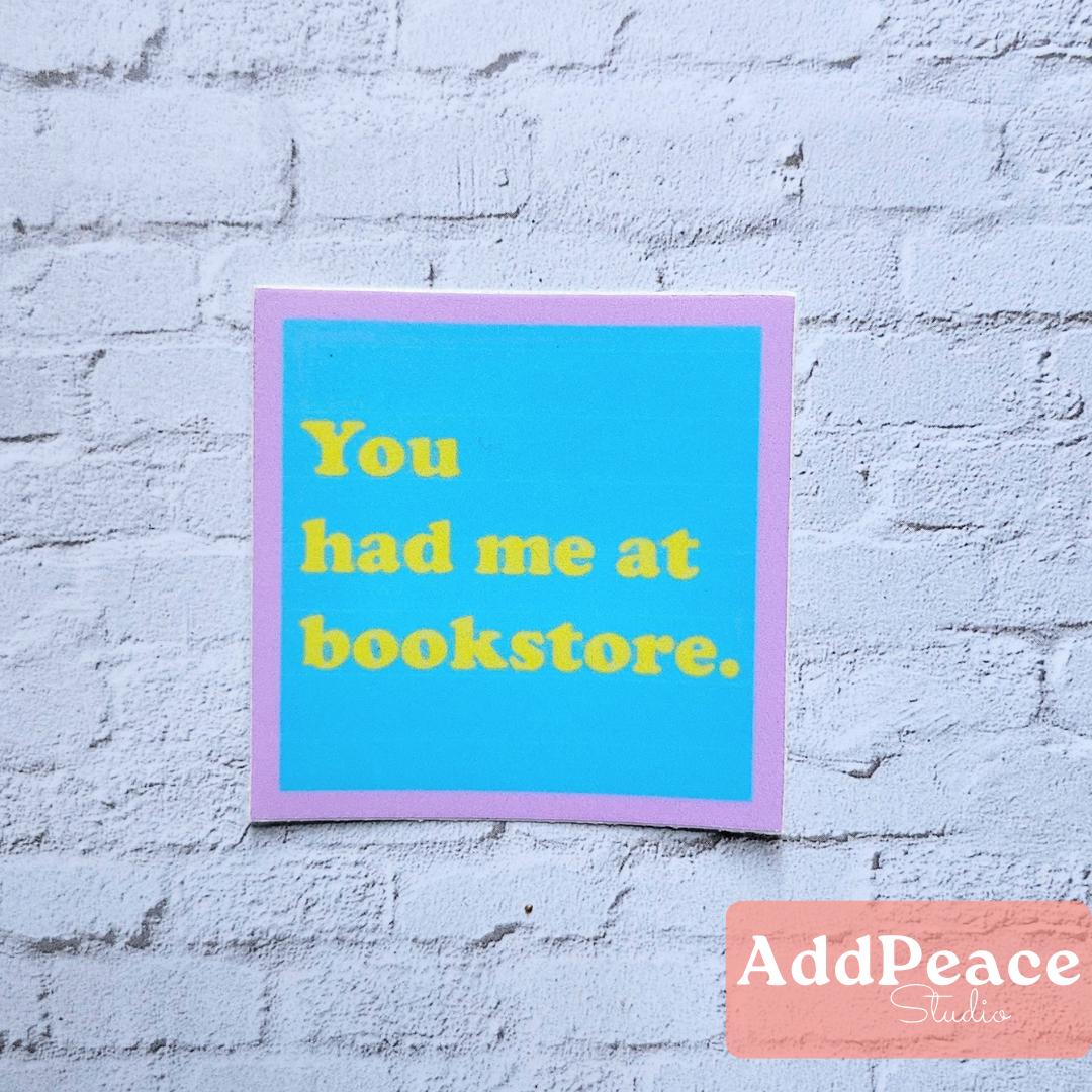 Framed quote sticker 'You had me at bookstore.' on a textured white wall with 'AddPeace Studios' logo.